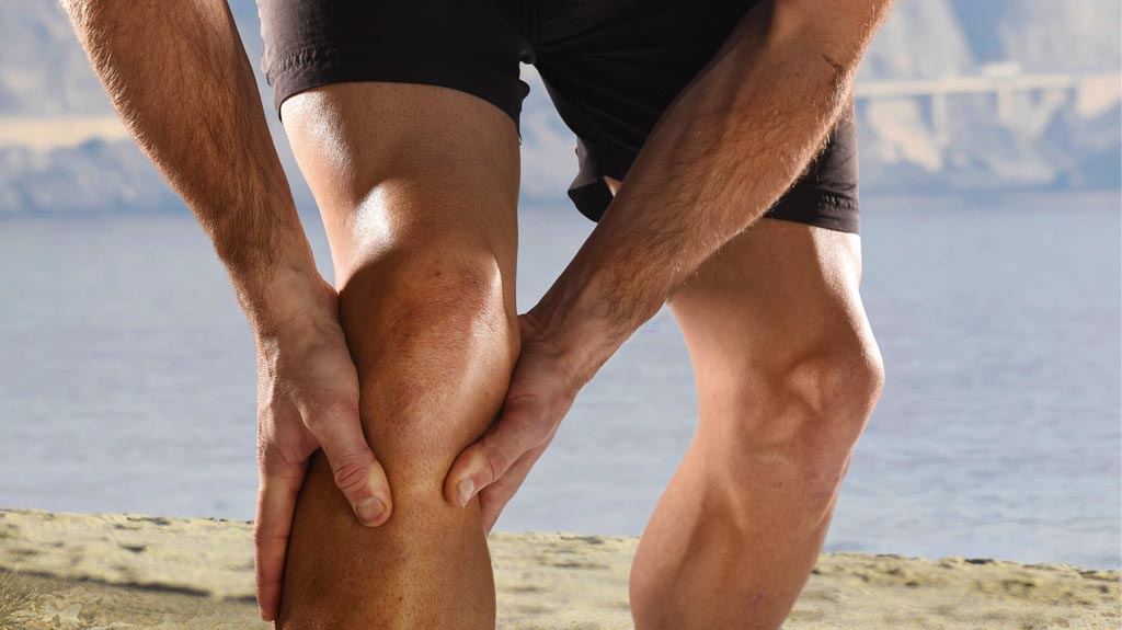 man holding his knee after an injury